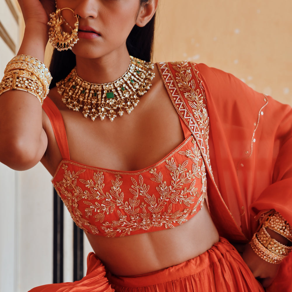 
                      
                        ORANGE BROAD STEP EMBROIDERED BLOUSE WITH BUTTI EMBROIDERED LEHENGA AND DUPATTA
                      
                    